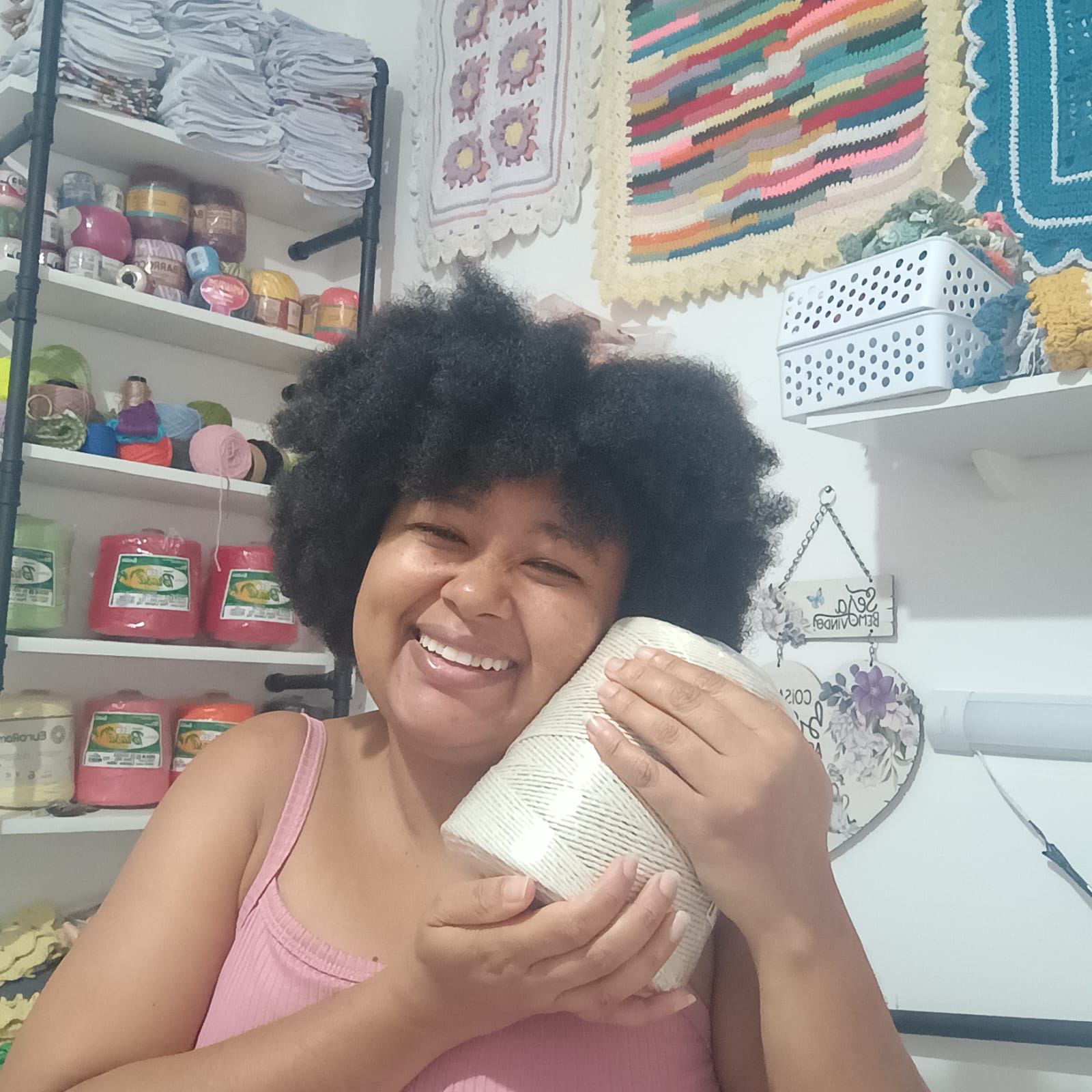 Arakania Karina no ateliê segurando um cone de barbante